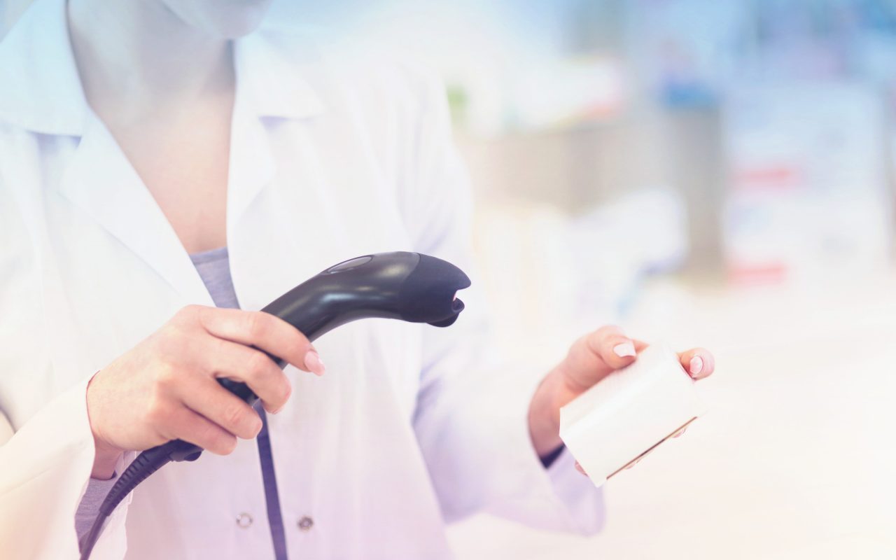 Arvato Systems_Gesundheitswesen_Woman scanning medicine box Arvato Systems_Gesundheitswesen_Woman scanning medicine box