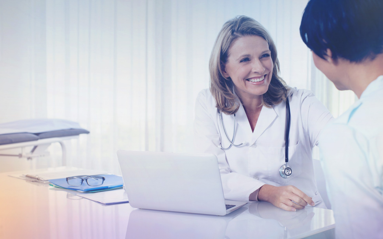 Arvato Systems_Gesundheitswesen_Female doctor with stetoscope smiling at patient