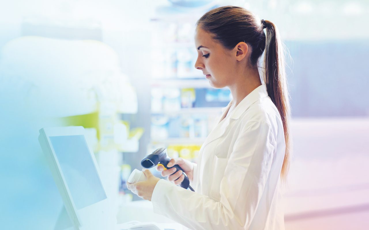Arvato Systems_Gesundheitswesen_Woman sideways scanning medicine box Arvato Systems_Gesundheitswesen_Woman sideways scanning medicine box