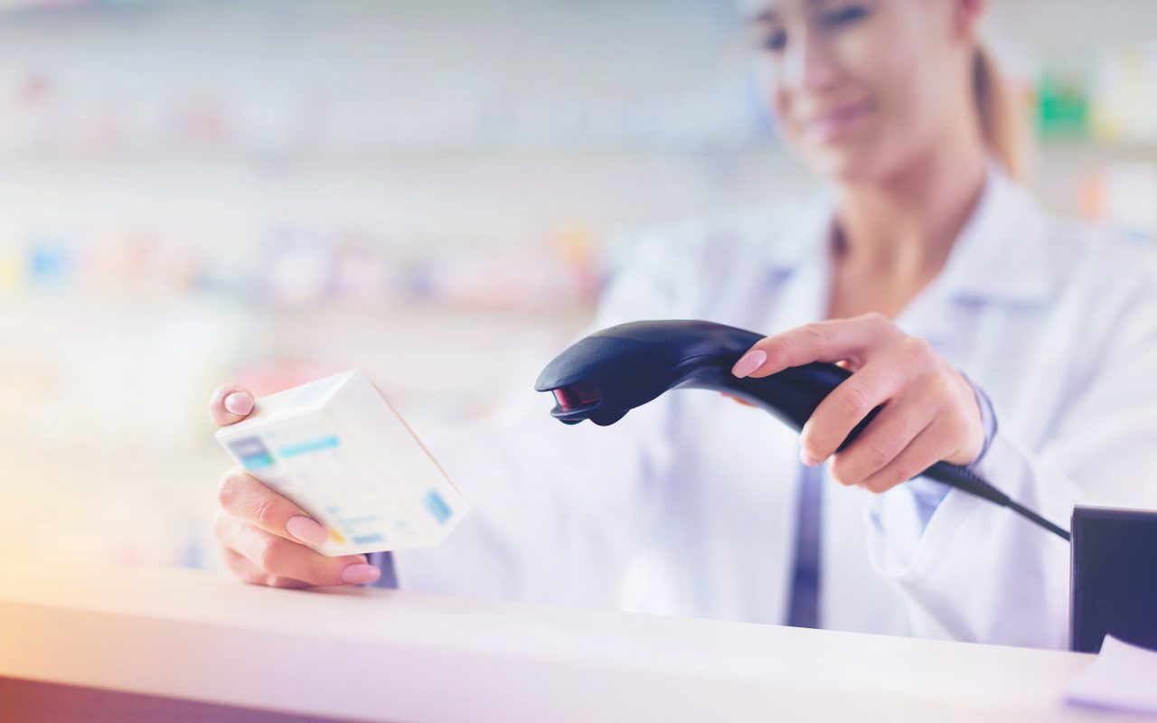 Arvato Systems_Gesundheitswesen_Woman scanning medicine box Arvato Systems_Gesundheitswesen_Woman scanning medicine box