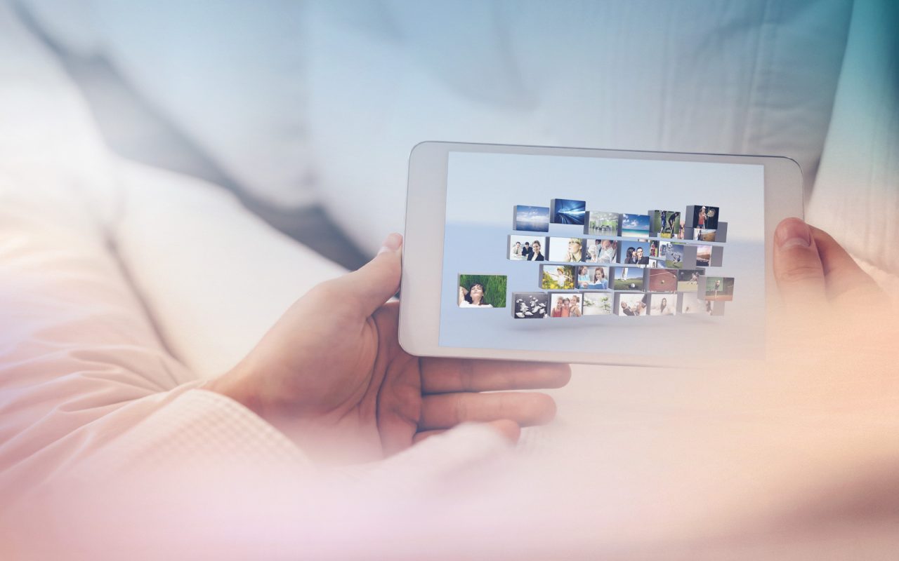 Arvato Systems_Medien_Woman on couch with smartphone with broadcast applications Arvato Systems_Medien_Woman on couch with smartphone with broadcast applications